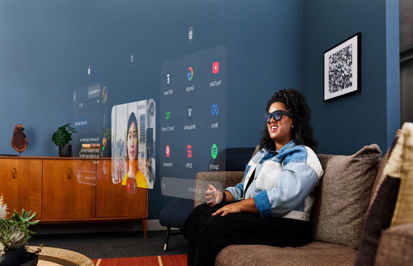 امرأة تجلس على أريكة وترتدي نظارات Orion من Meta، و التي تم الاعلان عنها في حدث Meta Connect 2024